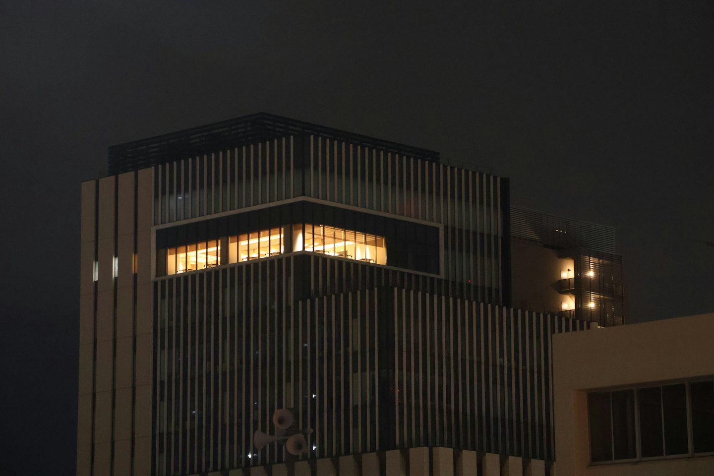 Edificio de oficinas moderno iluminado por la noche.